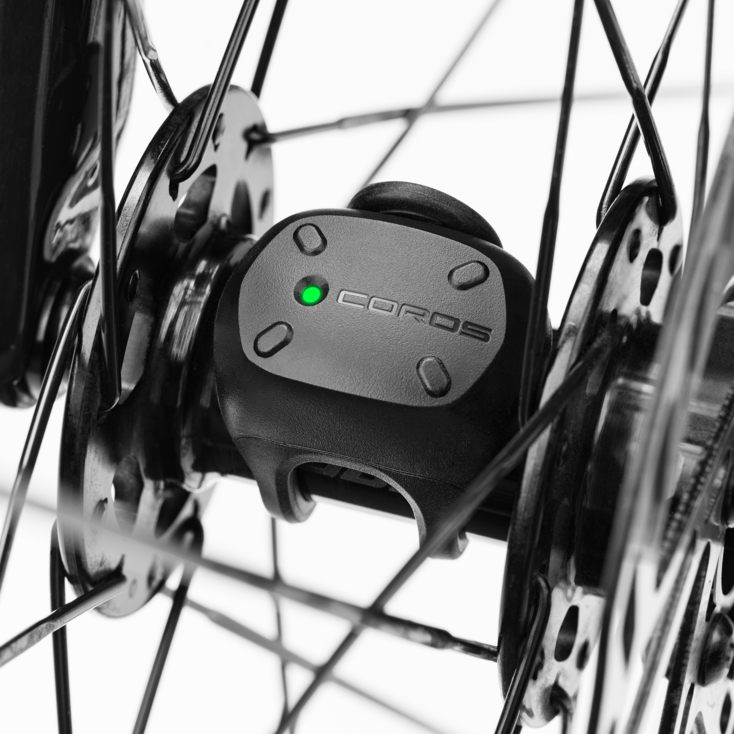 Close-up of a COROS Bike Speed Sensor mounted on a bike wheel hub